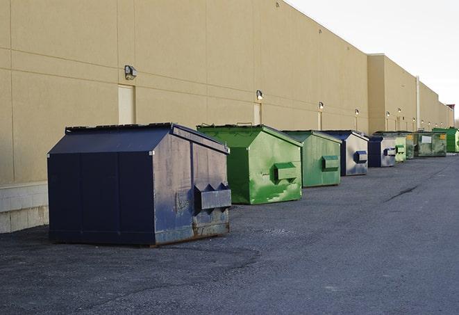 a waste management truck unloading into a construction dumpster in Azusa CA